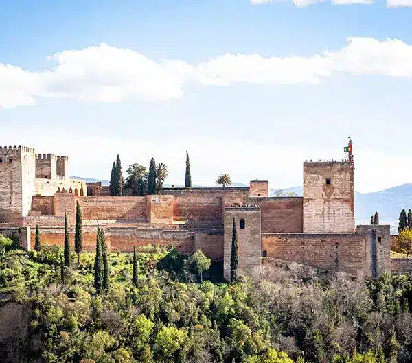 Forteresse de l’Alhambra de Grenade entourée de cyprès, étape du voyage moto en Andalousie