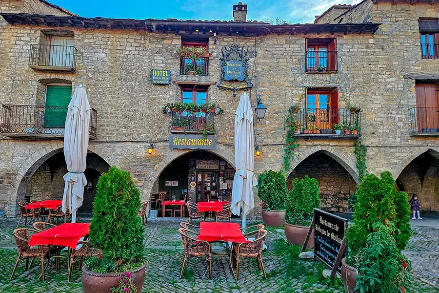 Terrasse de restaurant sur la place médiévale d’Aínsa dans les Pyrénées aragonaises